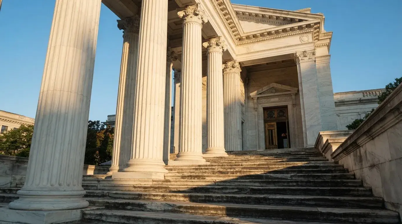 Coloane de marmură ale unei clădiri vechi, cu trepte late scăldate în soarele dimineții — blackjack pe bani reali în românia